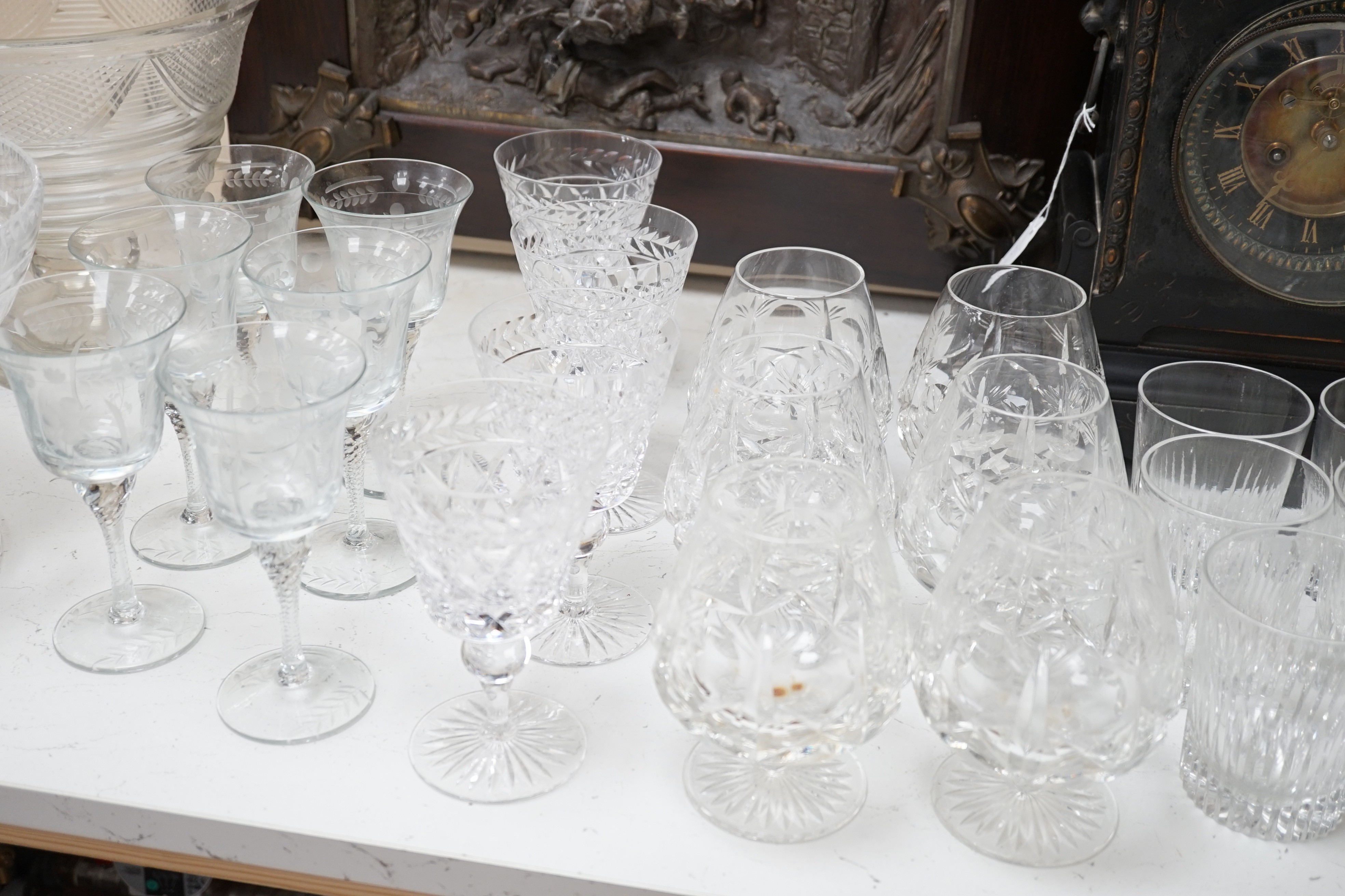 Assorted suites of cut glass wine glasses, brandy balloons, a pedestal water jug, two pedestal bowls